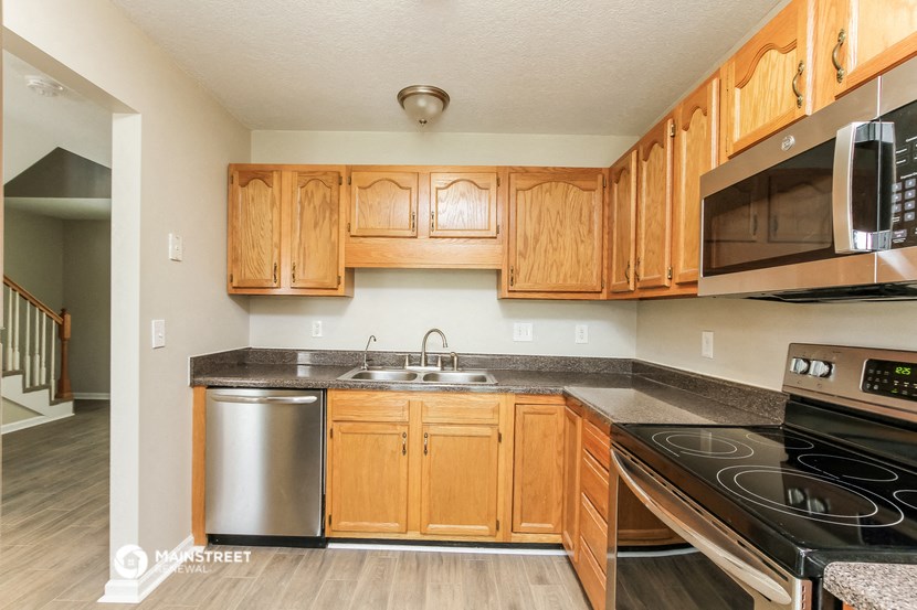 a kitchen with wooden cabinets and stainless steel appliances
