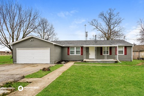 a gray house with red shutters and a driveway