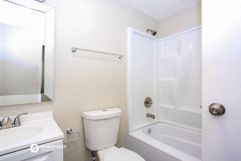 a white bathroom with a shower toilet and sink