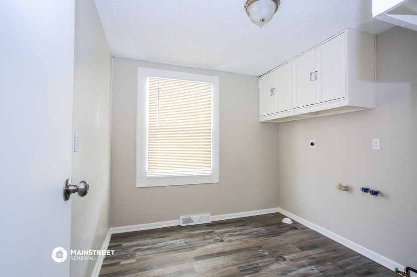 an empty room with white cabinets and a window