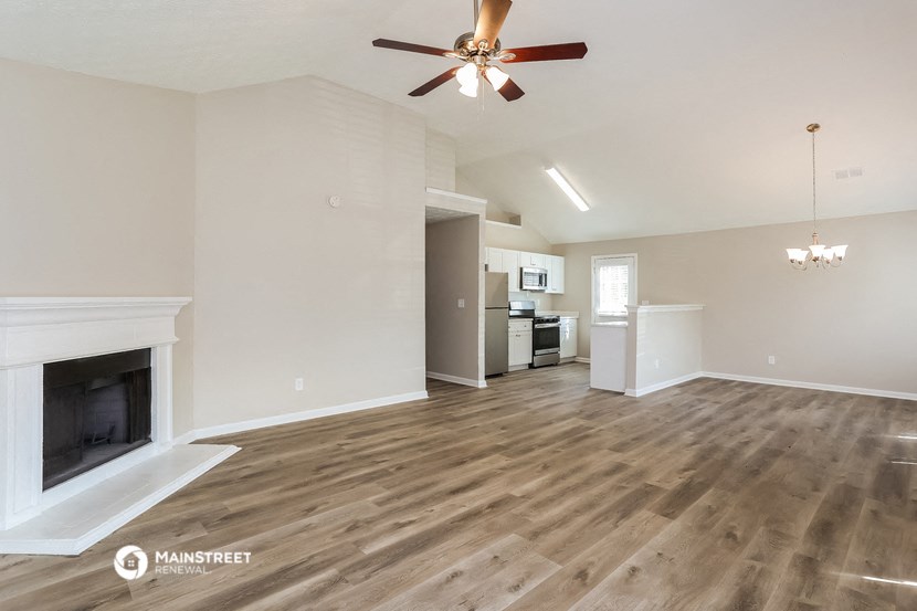 a living room with a fireplace and a ceiling fan