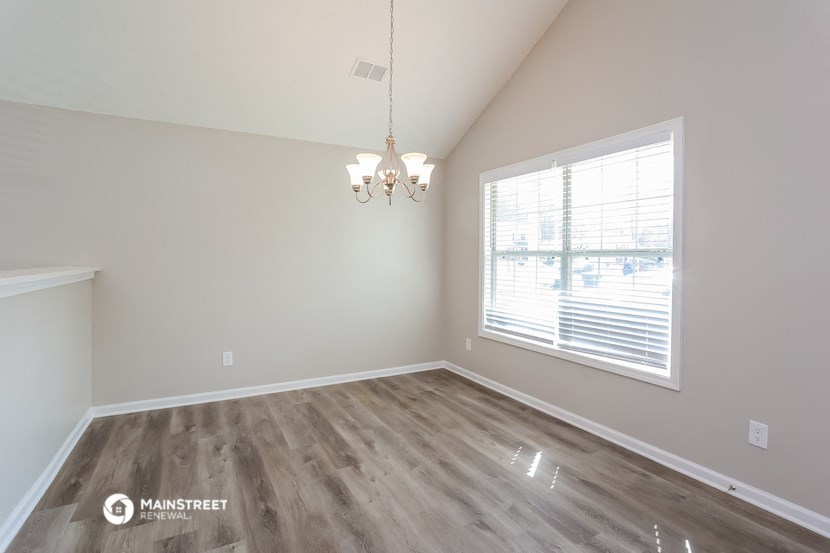 the spacious living room with a large window and wood flooring