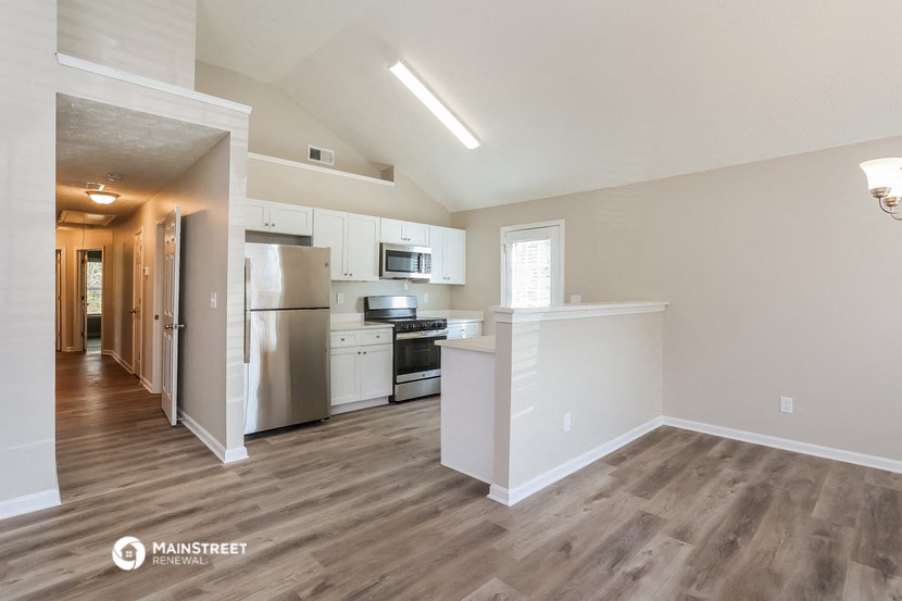 a kitchen with white cabinets and a stainless steel refrigerator