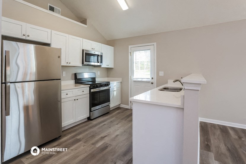 a kitchen with white cabinets and stainless steel appliances