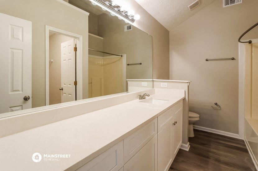 a bathroom with a large mirror and a white counter top