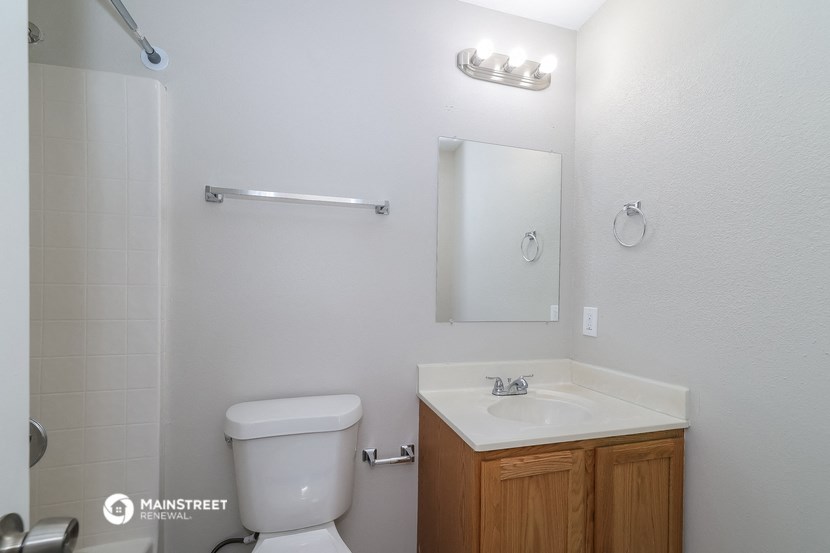 a bathroom with a toilet and a sink and a mirror