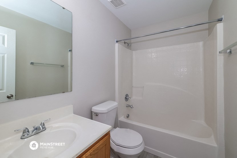 a bathroom with a shower toilet and sink and a mirror