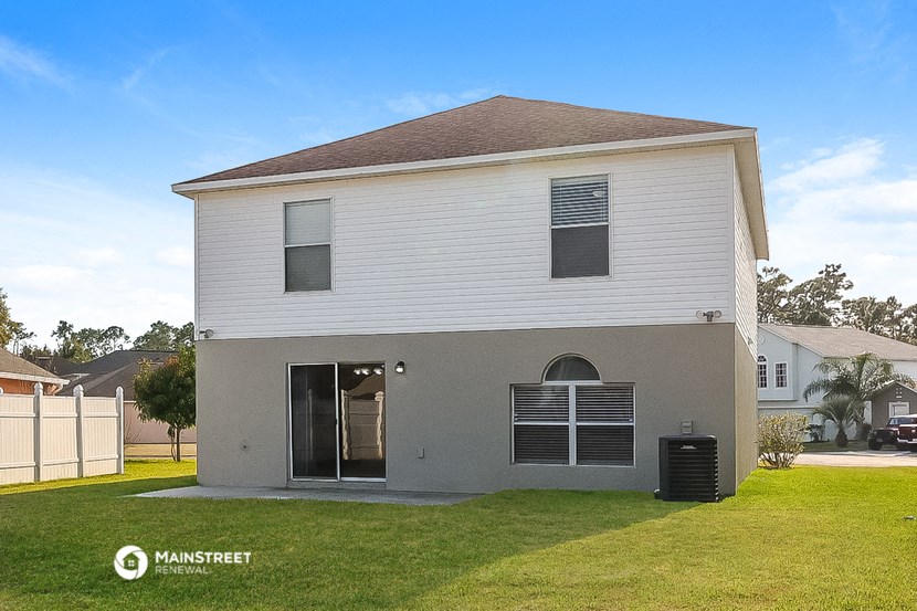 the front of a white house with a yard and a garage