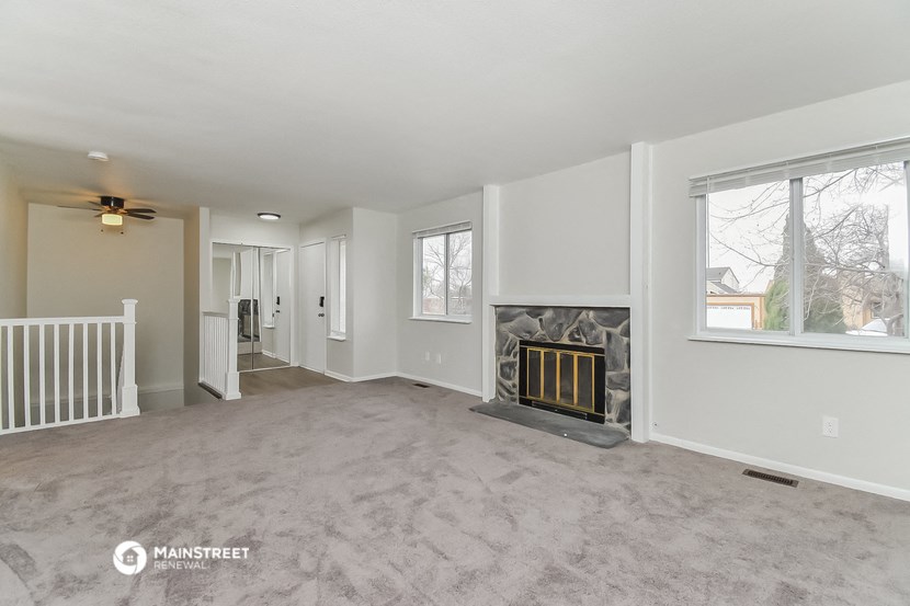 a living room with a fireplace and a large window