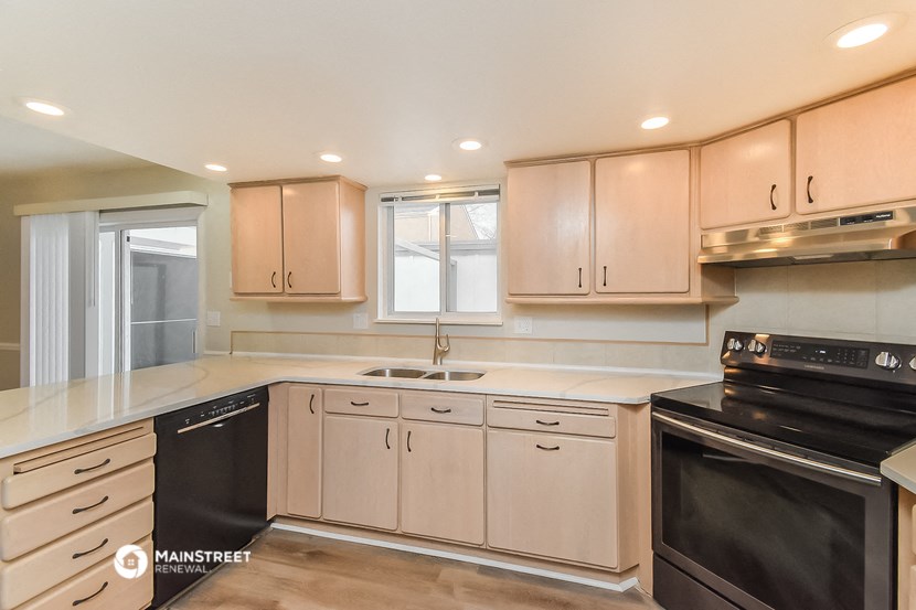 a kitchen with white cabinets and black appliances