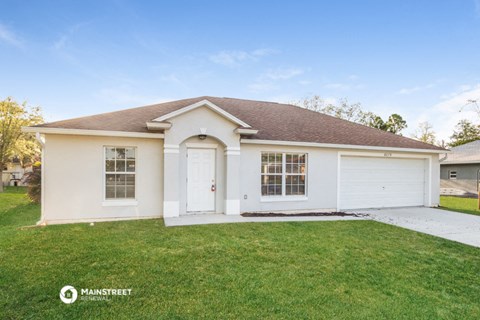 a white house with a lawn and a white garage door