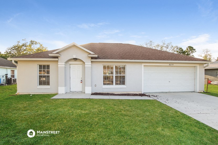a white house with a lawn and a white garage door
