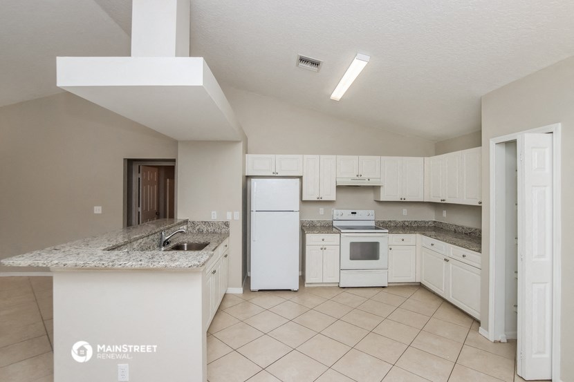 a kitchen with white appliances and granite counter tops