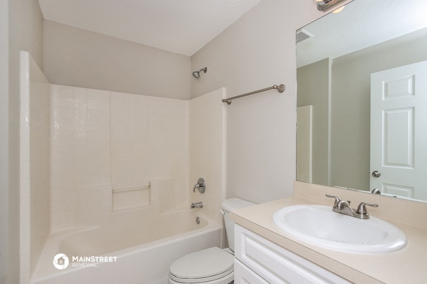a bathroom with a sink and a tub and a mirror