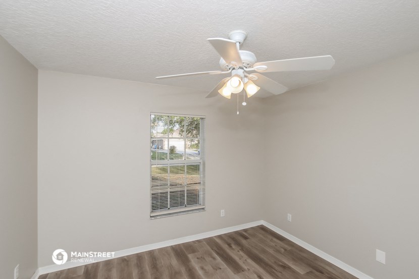the living room of our studio apartment atrium with ceiling fan and window