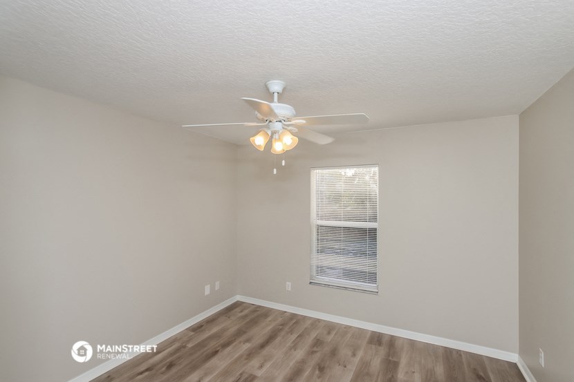 a bedroom with a ceiling fan and a window