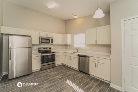 a kitchen with white cabinets and stainless steel appliances
