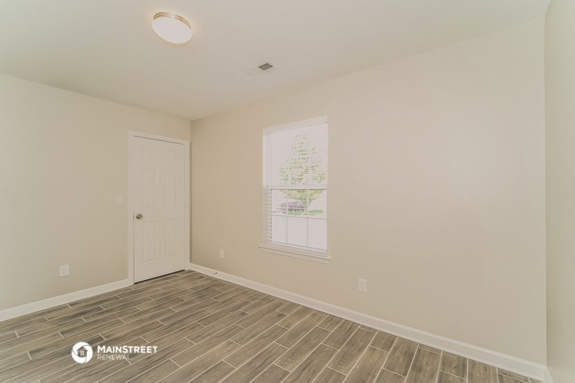 the spacious living room with vinyl flooring and a white door