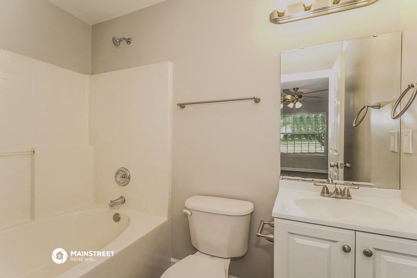 a bathroom with a toilet and a tub and a sink