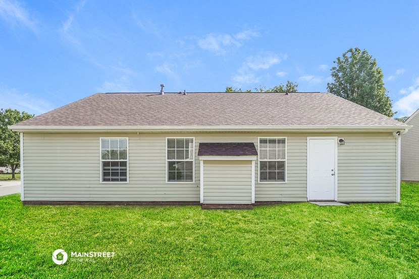 the front of a white house with a white garage door