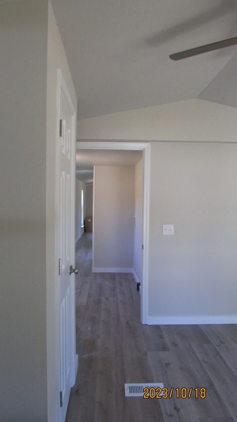an open living room and hallway with white walls and wood floors
