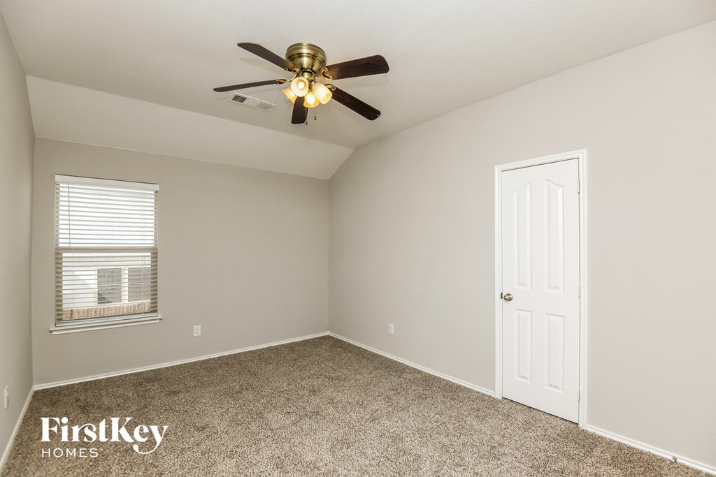 a bedroom with a ceiling fan and a white door