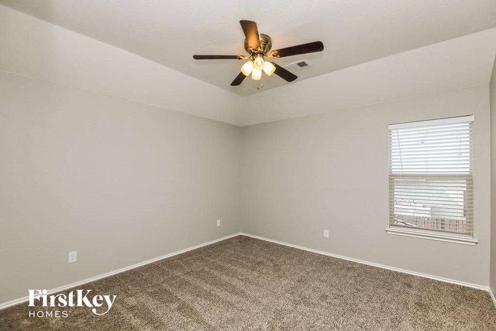 a bedroom with a ceiling fan and a window