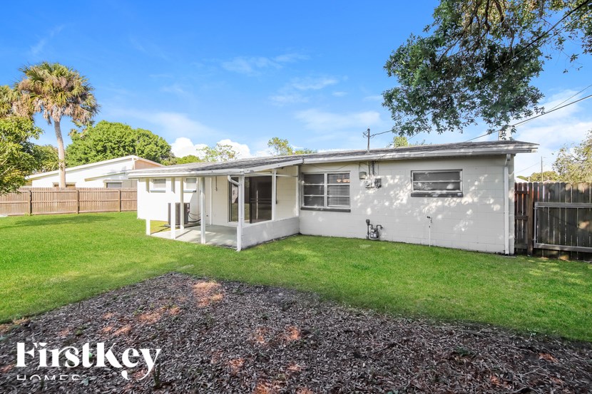 A house with a gravel driveway and a grassy lawn.