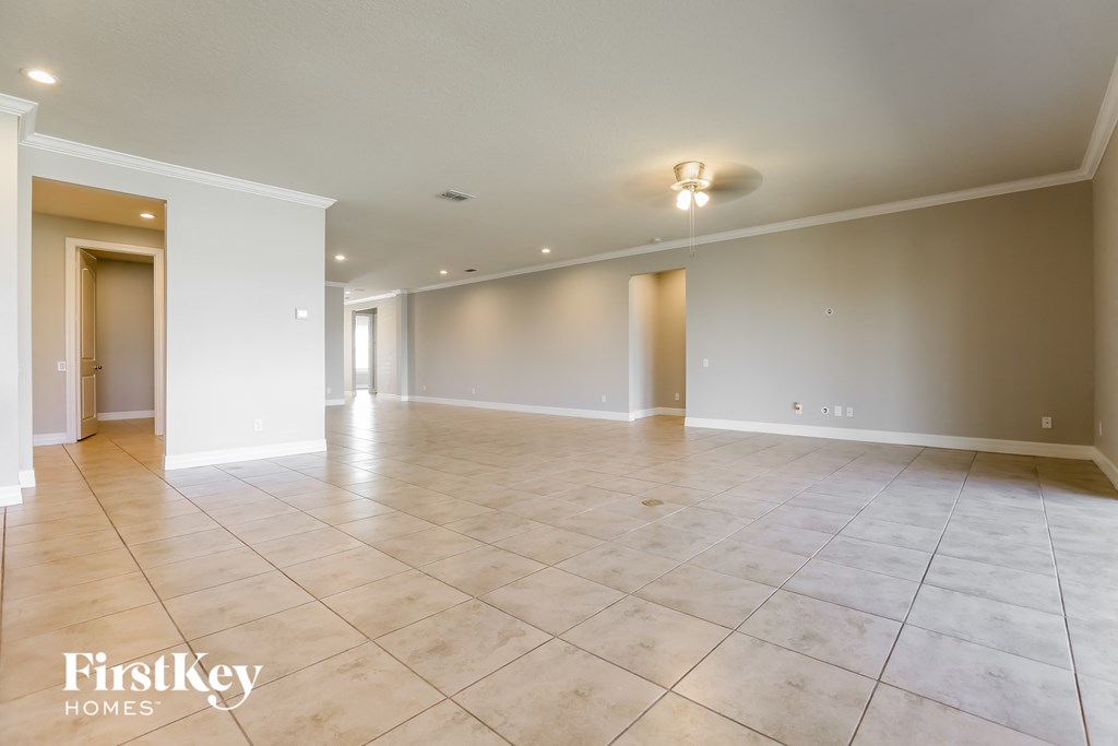 an empty living room with tile flooring and white walls