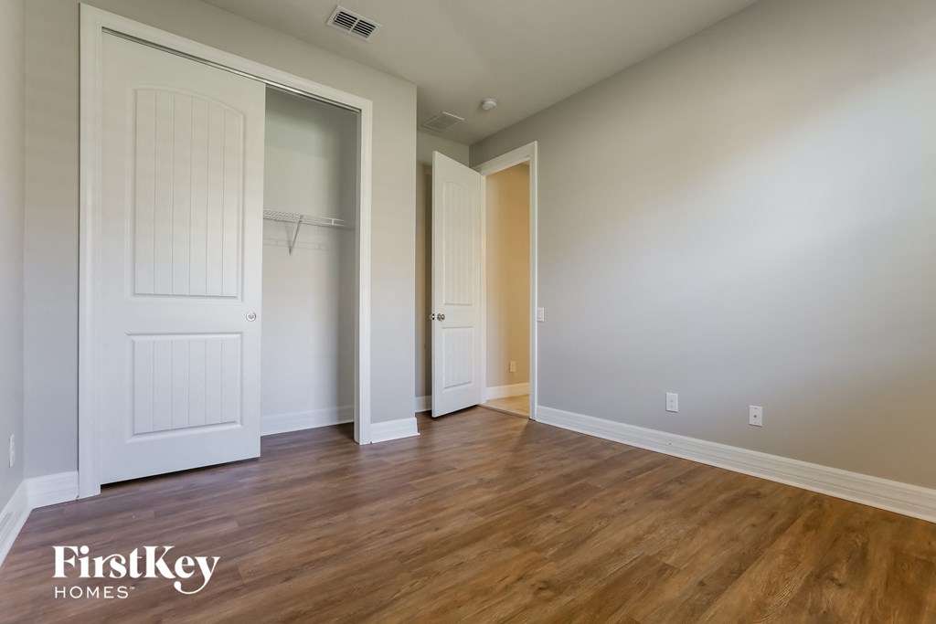 a bedroom with a closet and a hard wood floor