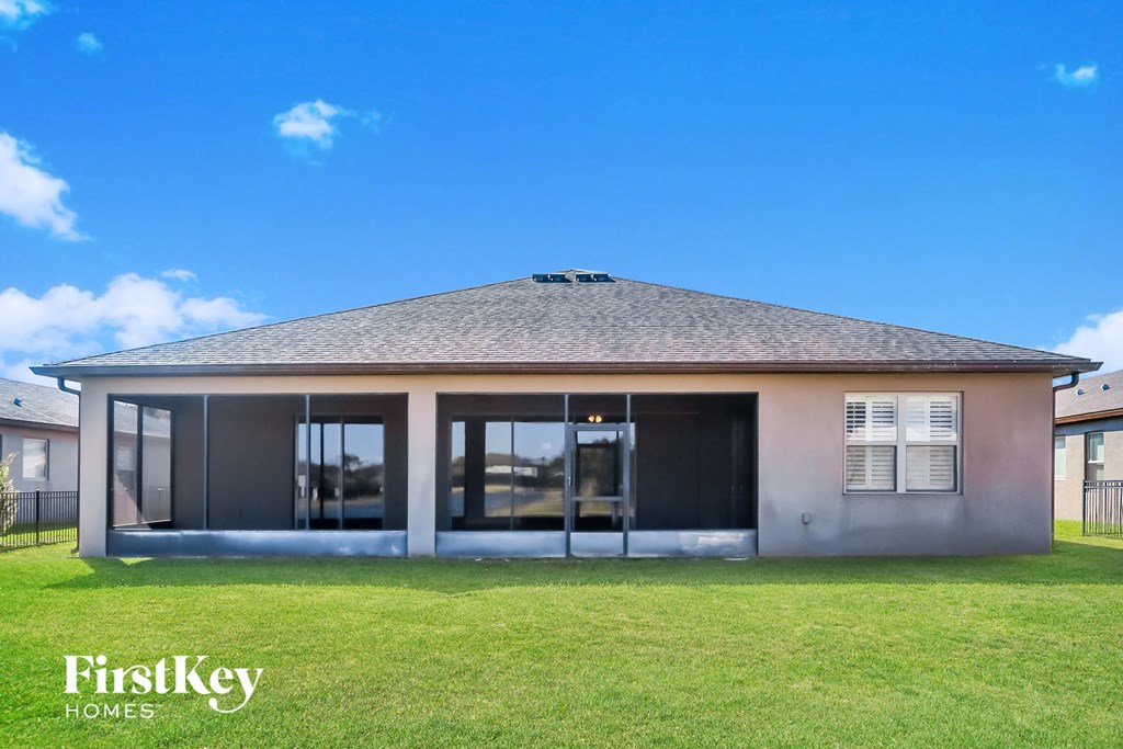 a house with a grass lawn and a blue sky
