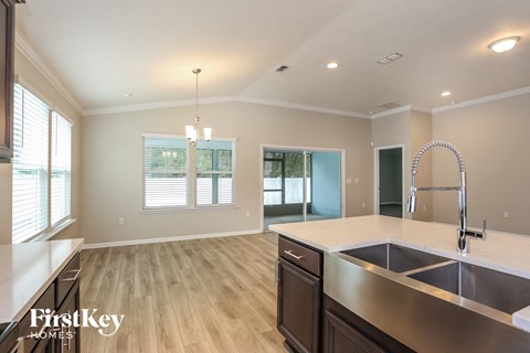 a kitchen and living room with a sink and a faucet