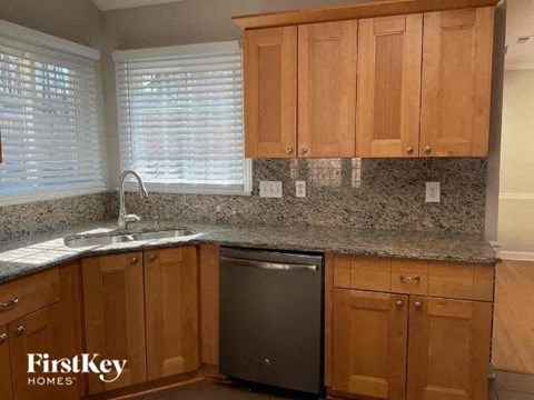 a kitchen with wooden cabinets and a stainless steel dishwasher