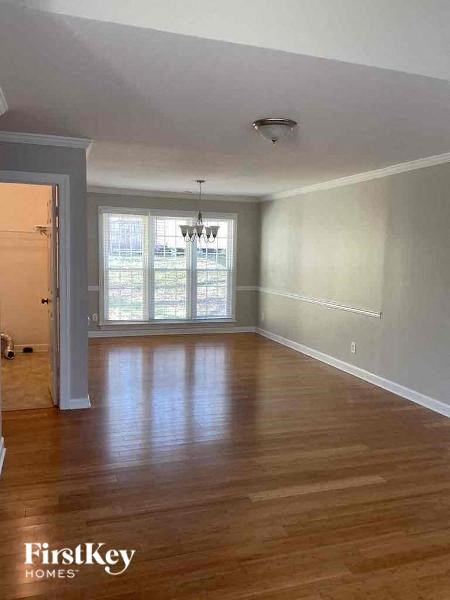an empty living room with wood floors and a window