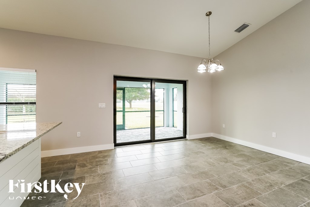 A spacious room with a sliding glass door leading to a balcony.