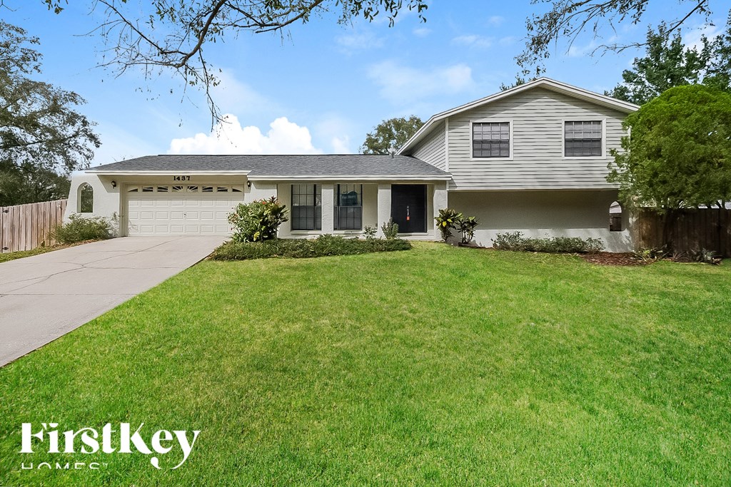a white house with a lawn and a driveway