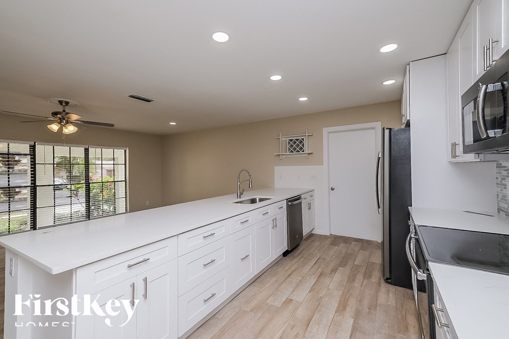 a large kitchen with white cabinets and a white counter top