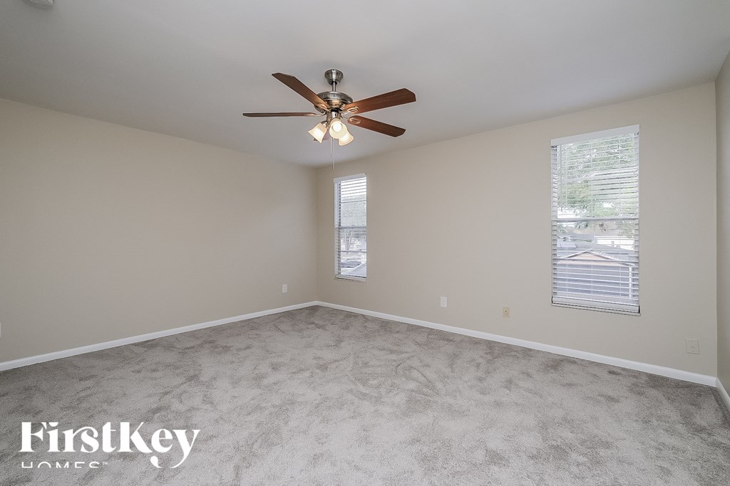 a bedroom with carpet and a ceiling fan