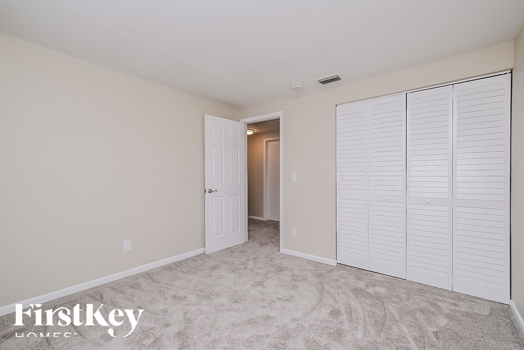 a bedroom with a closet and a door to a hallway