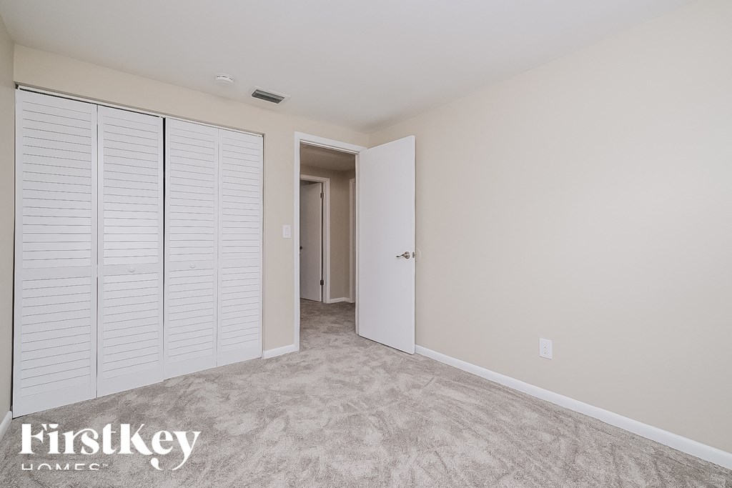 a bedroom with a closet and a door to a hallway