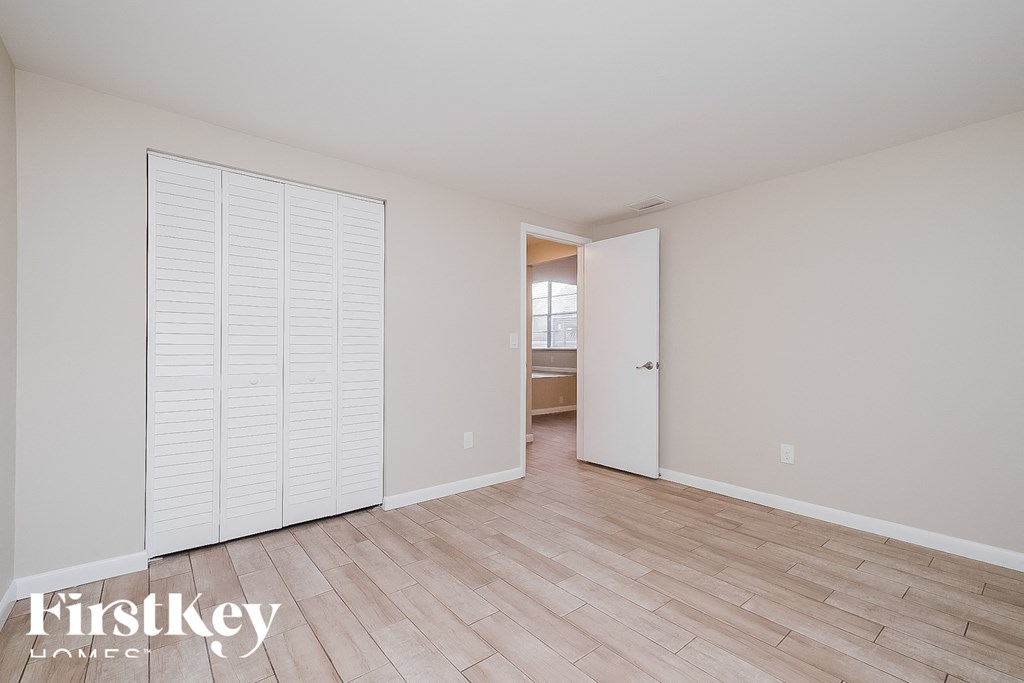 a master bedroom with a large closet and a hardwood floor