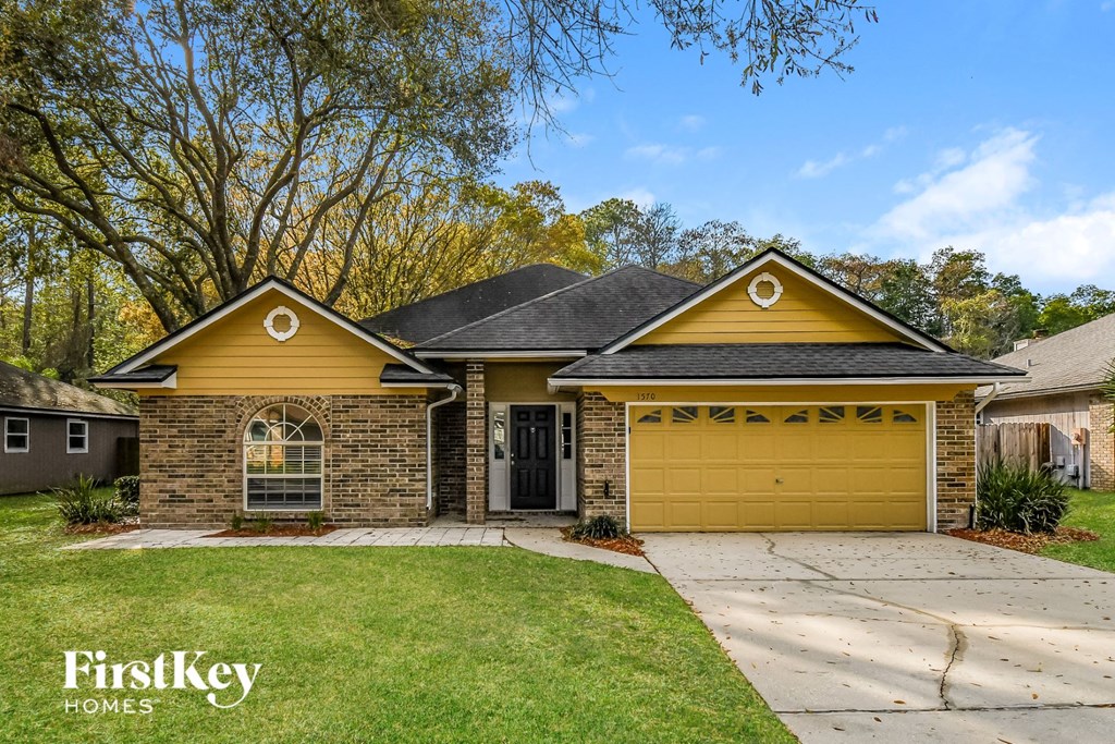 a yellow brick house with a yellow garage door