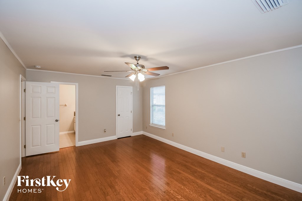 a living room with wood floors and a ceiling fan