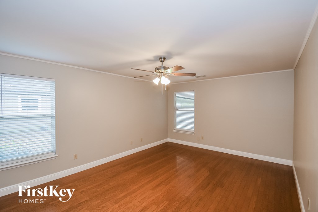 a bedroom with wood flooring and a ceiling fan