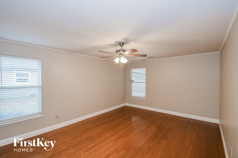 a bedroom with wood flooring and a ceiling fan