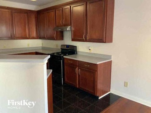 A kitchen with wooden cabinets and a black stove top oven.