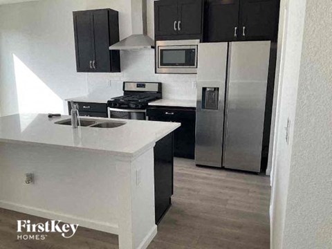 A kitchen with a white counter top and stainless steel appliances.