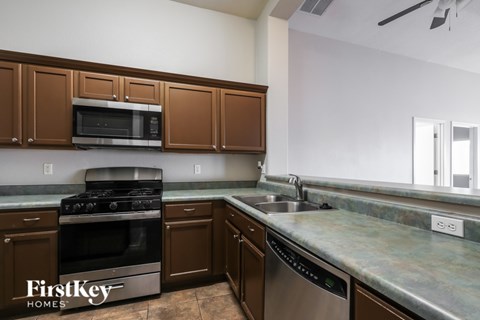 A kitchen with brown cabinets and a stainless steel dishwasher.