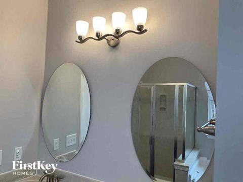 a bathroom with two mirrors and a light on the wall