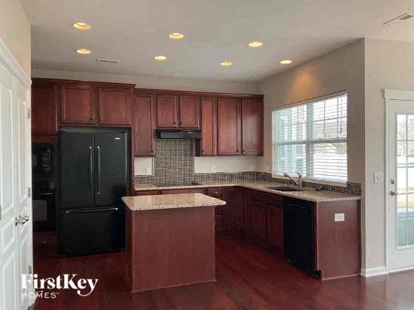 a large kitchen with black appliances and wooden cabinets